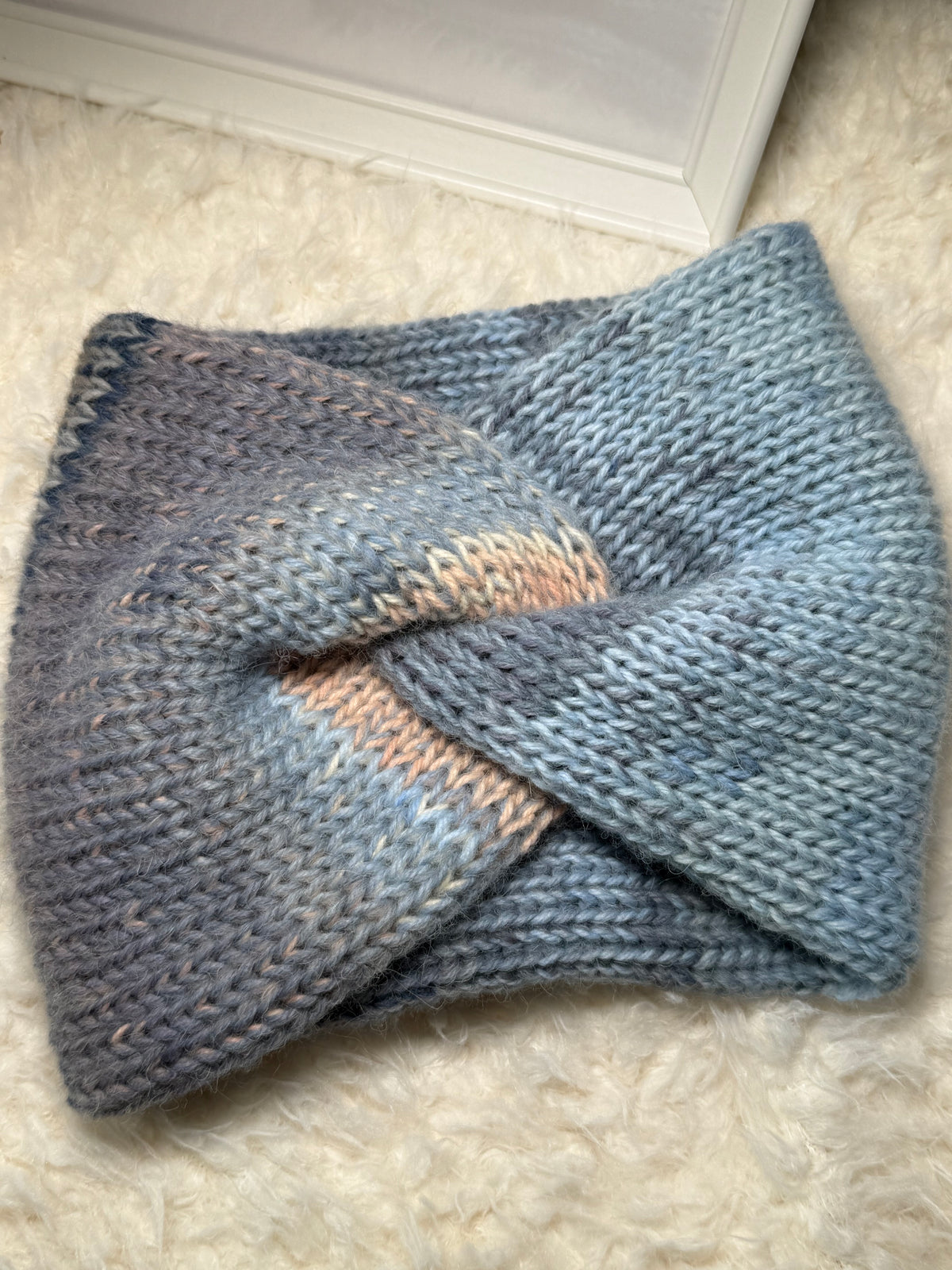 Gestricktes Stirnband mit Farbverlauf – Blautöne & Weiß – gedreht