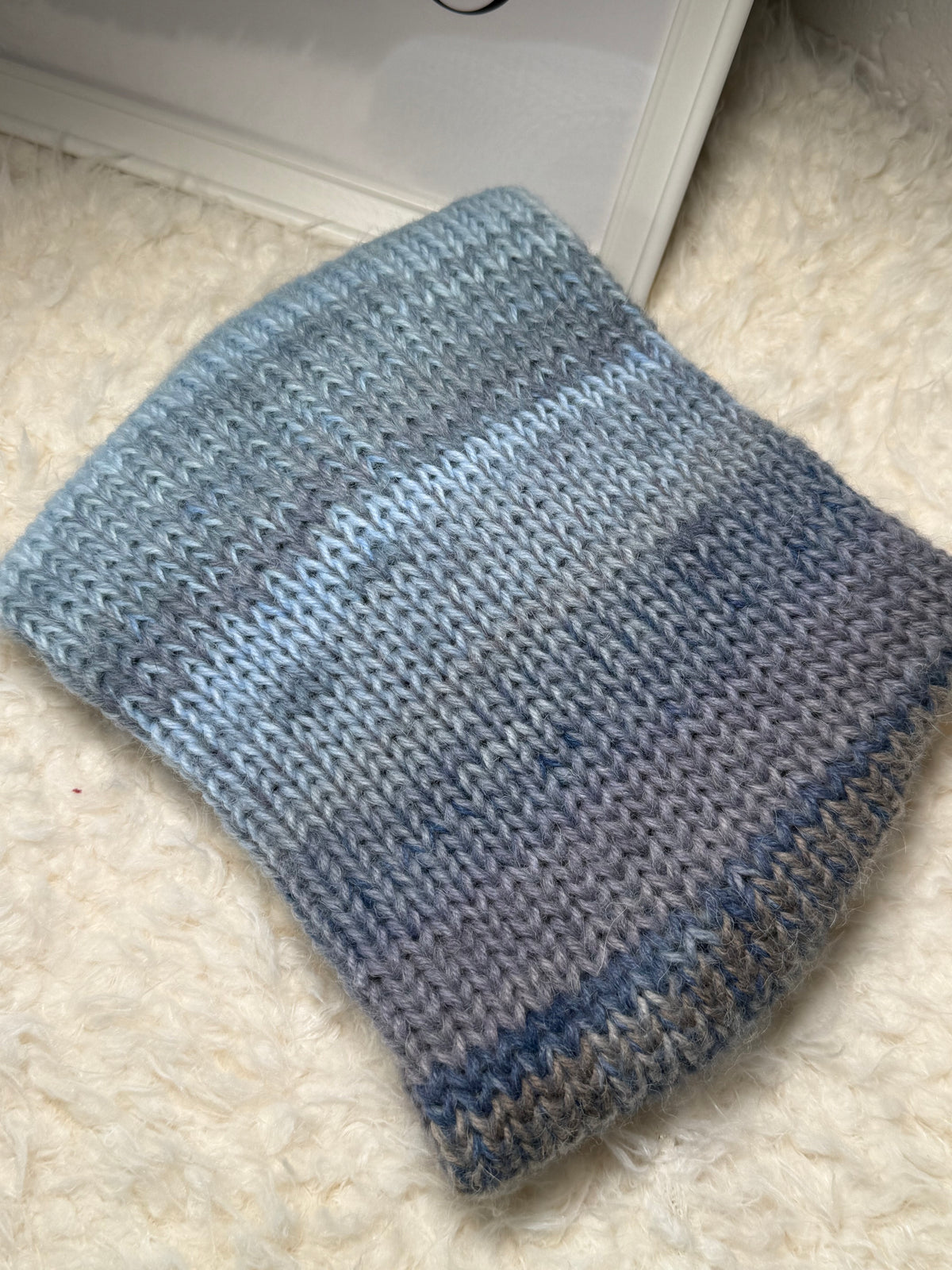 Gestricktes Stirnband mit Farbverlauf – Blautöne & Weiß – gedreht